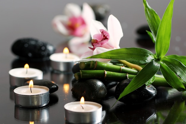 Spa and wellness, massage stones and flowers on wooden tablecloth