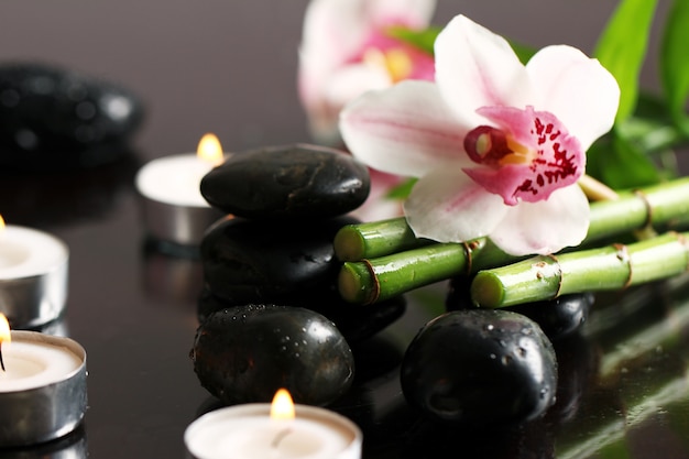 Spa and wellness, massage stones and flowers on wooden tablecloth