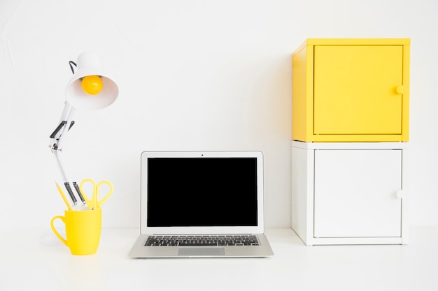 Spacious workplace in white and yellow colors with metal boxes