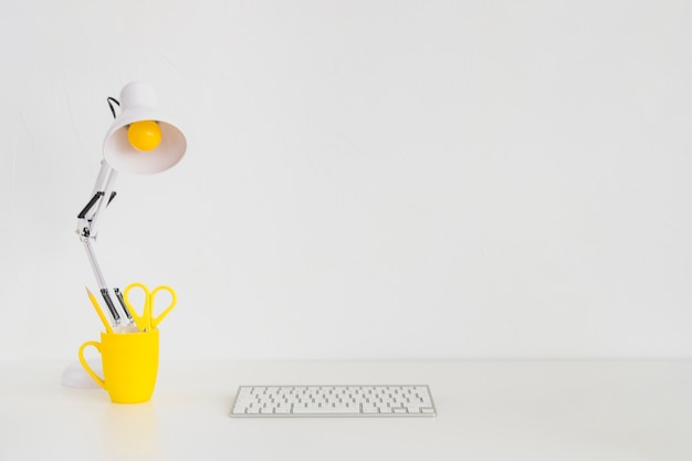 Spacious workplace with yellow mug and keyboard