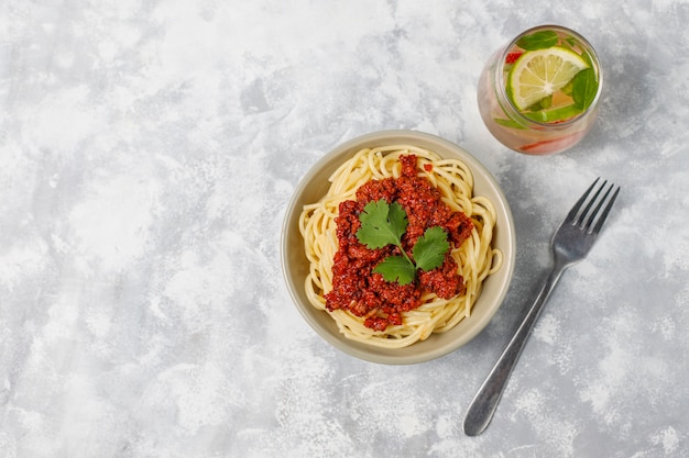 Free Photo spaghetti bolognese and lemonade on grey concrete 