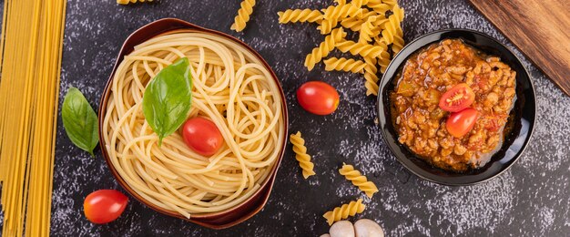 Free Photo spaghetti saute in a gray plate with tomatoes and basil