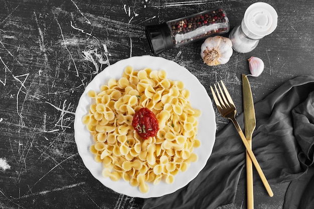 Free photo spaghetti in tomato sauce in a white plate, top view.