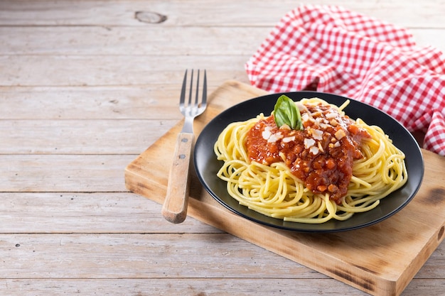 Spaghetti with bolognese sauce on wooden table