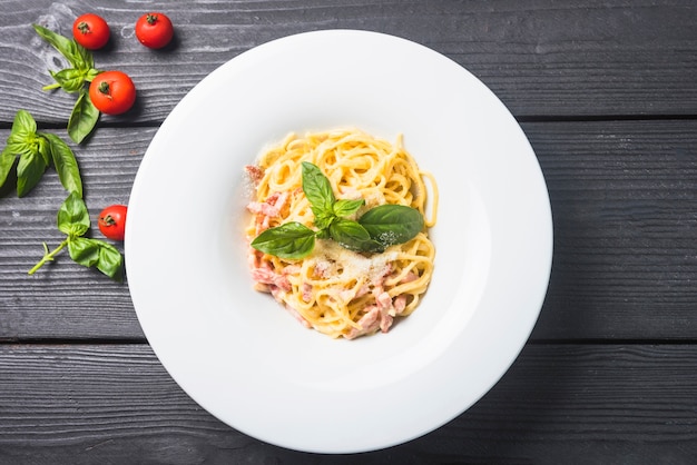 Free photo spaghetti with cheese and basil on a plate