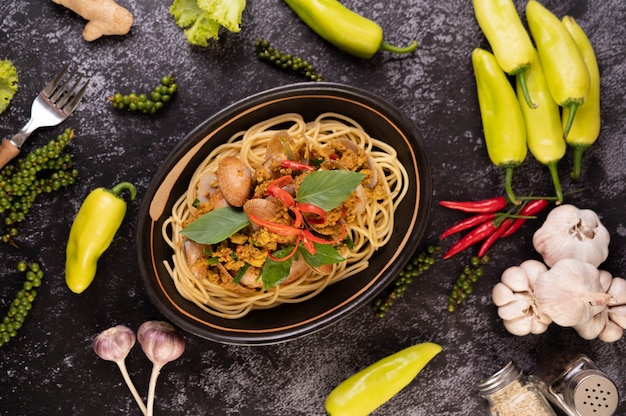 Spaghetti with Clams in a Black Plate with Chilies Fresh garlic and pepper.