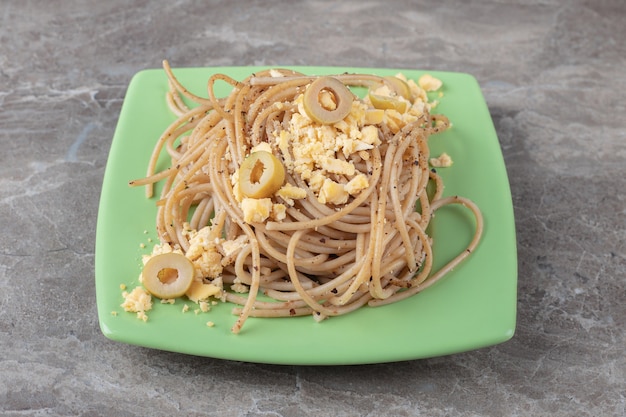 Free photo spaghetti with fried eggs on green plate.