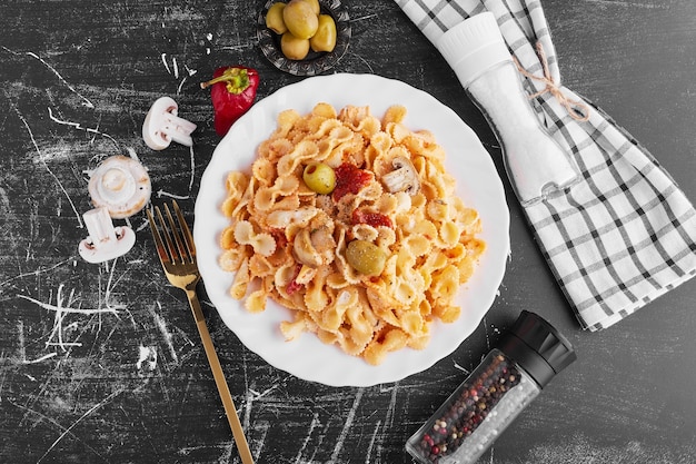 Spaghetti with mixed ingredients in a white plate, top view. 