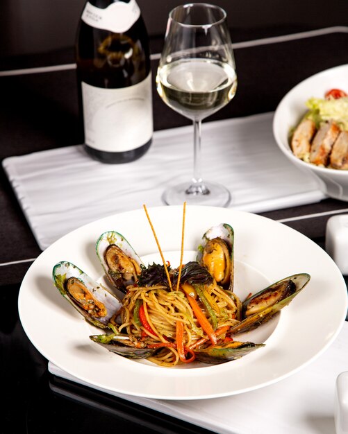 Spaghetti with mussels and bell peppers served with white wine