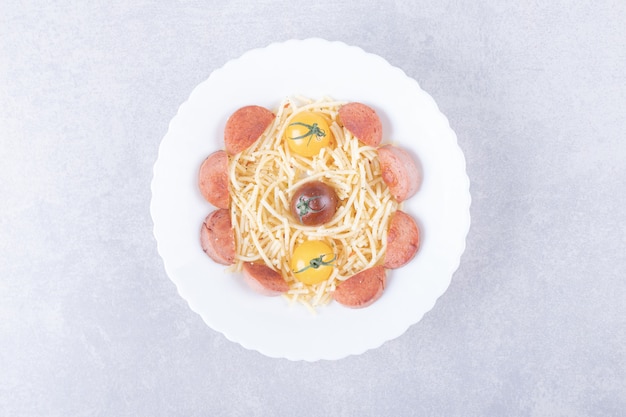 Free photo spaghetti with roasted sausages and tomatoes in white bowl.