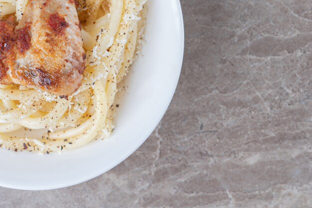 Spaghetti with tomato sauce in a bowl , on the marble surface.