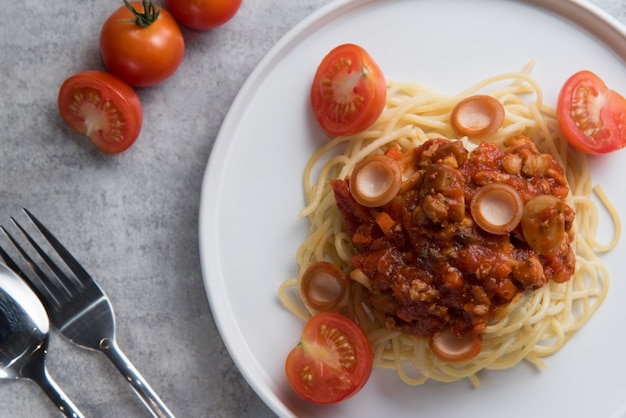 Free photo spaghetti with tomato sauce and sausage in white plate