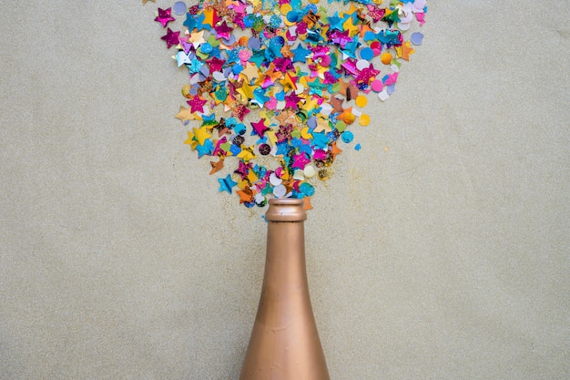 Spangles scattered from bottle on grey table