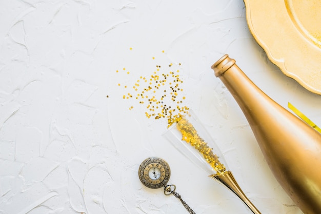 Free photo spangles scattered from glass with bottle