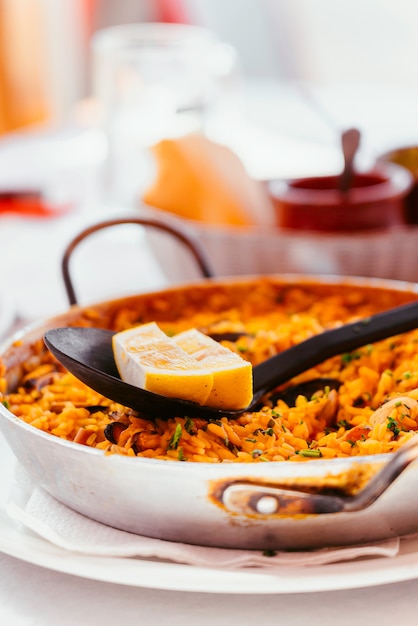 Free Photo spanish seafood paella with mussels, shrimps and a piece of lemon. in a steel paella pan. canary islands cousine in a small family restaurant.