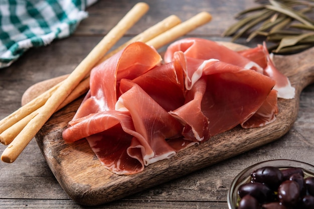 Free photo spanish serrano ham with olives and breadstick