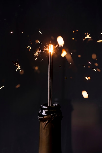 Sparkler in champagne bottle at night