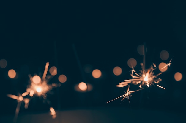 Sparklers burning in the dark bokeh background