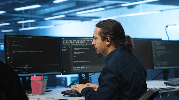 Free photo specialist at pc desk in high tech establishment overseeing server rows