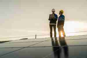 Free photo specialist technician professional engineer with laptop and tablet maintenance checking installing solar roof panel on the factory rooftop under sunlight engineers team survey check solar panel roof