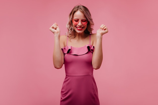 Free photo spectacular woman in pink dress smiling with eyes closed