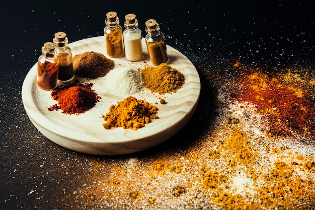 Free photo spices decoration with bottles on wooden plate