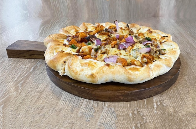 Free photo spicy chikcen tikka pizza on wood table