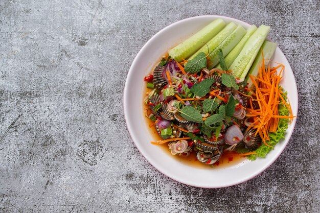 Spicy cockles salad on dark background