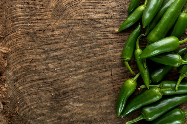 Spicy green pepper on wooden background