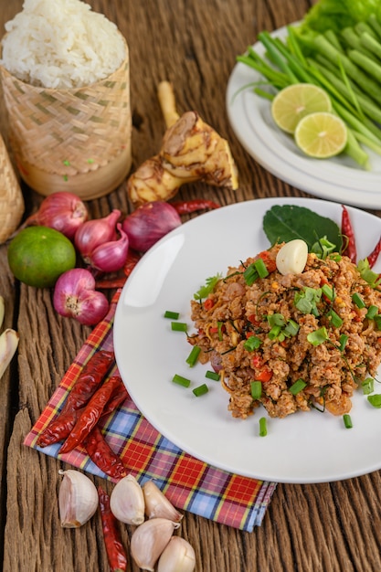 Free photo spicy minced pork on a white plate and sticky rice box