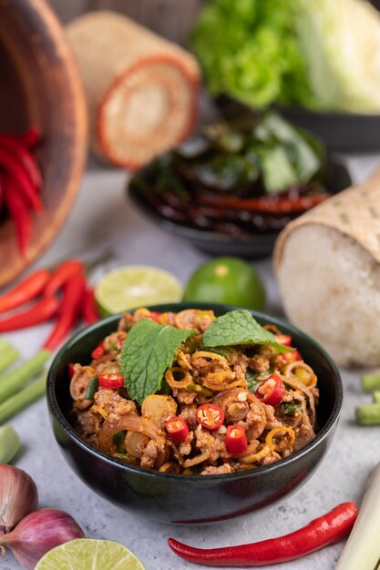 Spicy pork chops in a black cup consisting of lemons Chili and side dishes