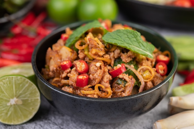 Spicy pork chops in a black cup consisting of lemons Chili and side dishes