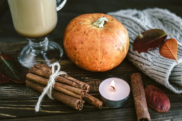 Free photo spicy pumpkin latte on a wooden board with a sweater