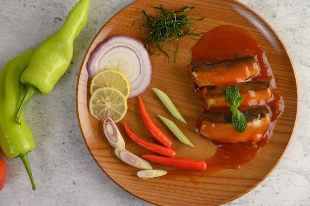 Spicy salad of sardine in tomato sauce on wooden tray