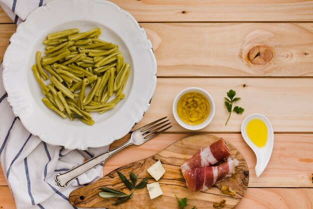 Spinach gemelli pasta; cheese; bacon and infused oil on wooden table