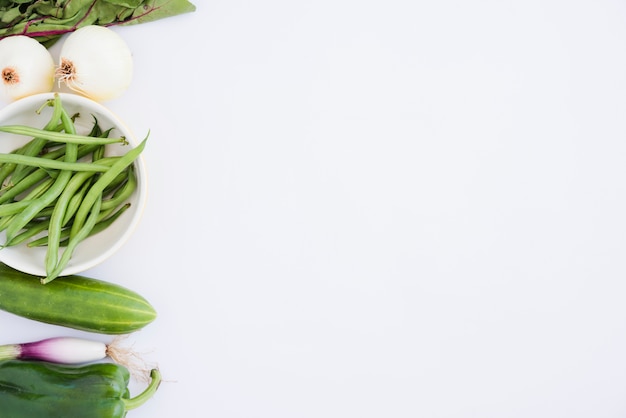 Free Photo spinach; onion; green beans; cucumber; bell pepper and scallion isolated on white background