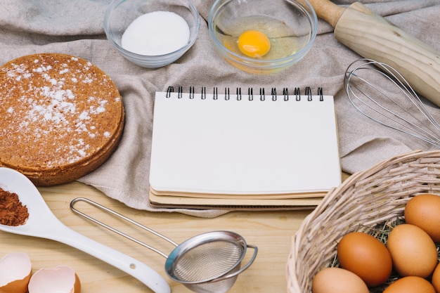 Spiral blank notepad with ingredients and tools for making cake