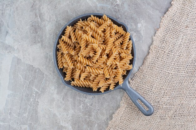 Spiral pastas in an iron pan on the marble