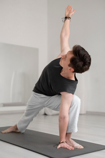 Spiritual young man practicing yoga in sportswear