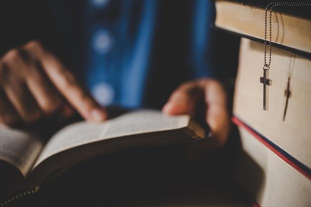 Spirituality and religion, Hands folded in prayer on a Holy Bible in church concept for faith.