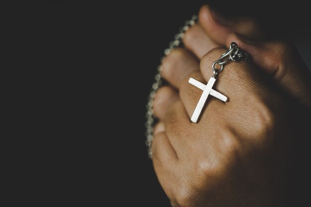 Spirituality and religion,Women in religious concepts Hands praying to God while holding the cross symbol. Nun caught the cross in his hand. 