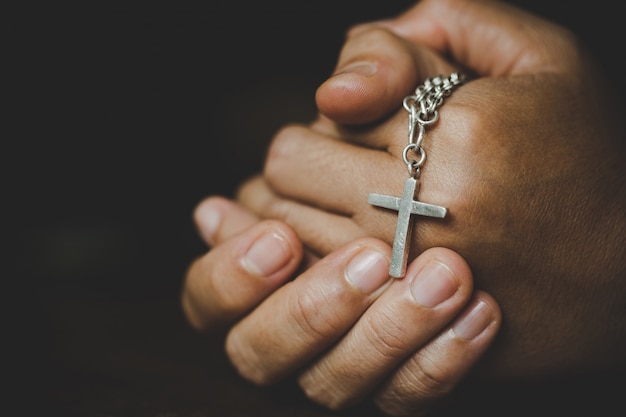 Spirituality and religion,Women in religious concepts Hands praying to God while holding the cross symbol. Nun caught the cross in his hand. 