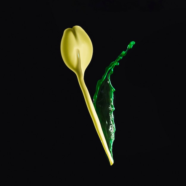 Free Photo splashing yellow and green paint forming flower bud over dark backdrop