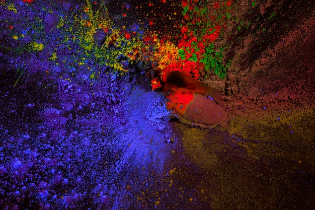 Free photo splatter of holi color powder over black surface