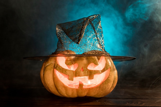 Free photo spooky carved pumpkin with hat