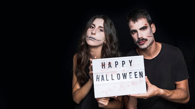 Spooky friends holding signboard