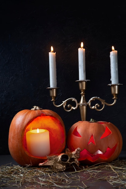 Free photo spooky halloween carved pumpkin lantern with candelabra