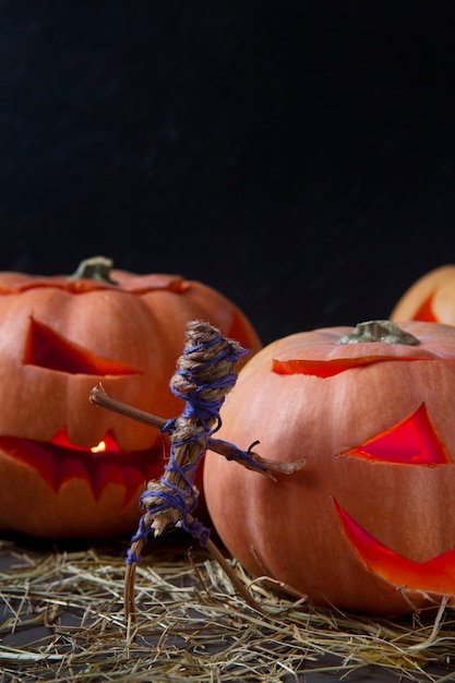 Free Photo spooky halloween carved pumpkin lantern with figurine made out of sticks