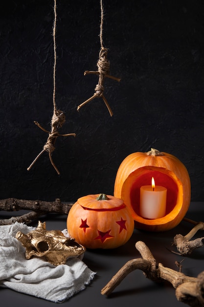 Free photo spooky halloween carved pumpkin lanterns with hanging stick figures