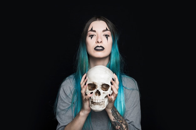 Spooky woman holding human skull